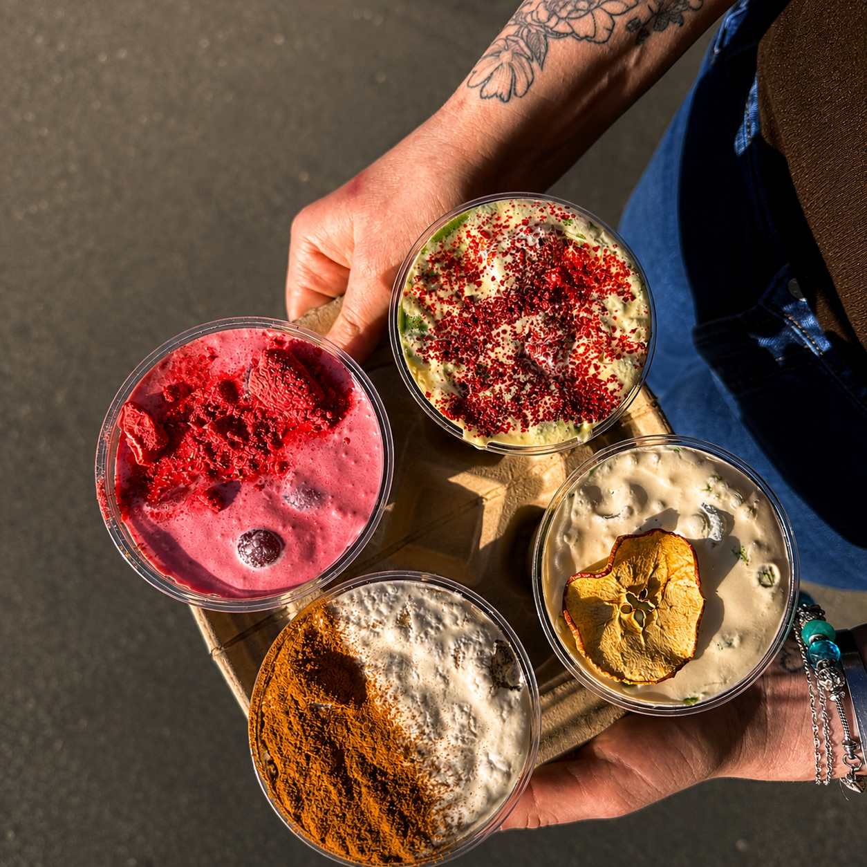 Four colourful drinks held together in the sunlight at Heirloom Café
