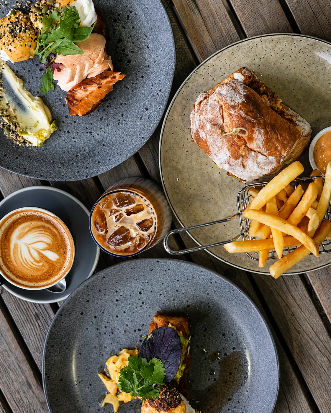 A table spread with café dishes, coffee and fries