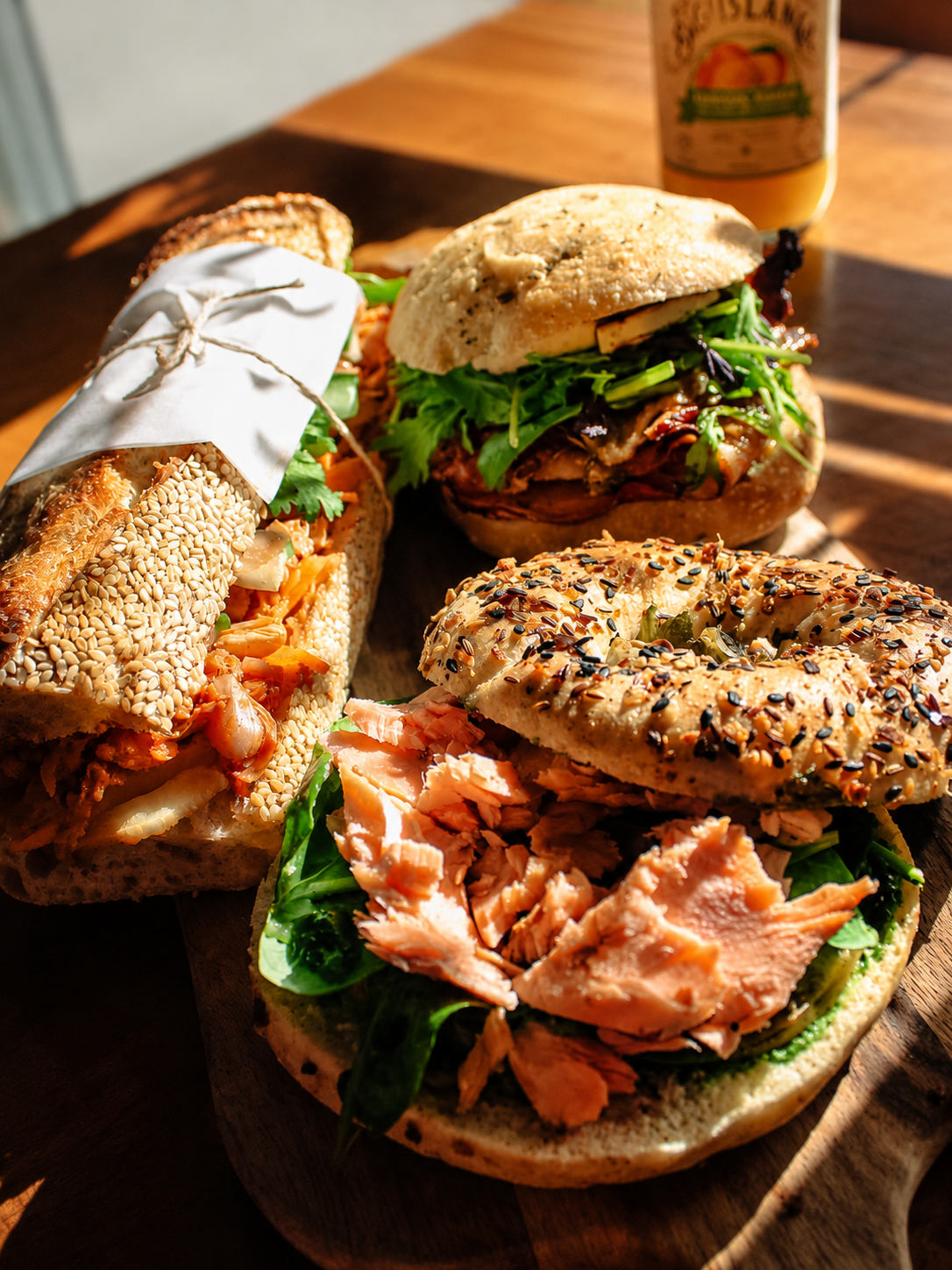A sunlit spread of bagels and sandwiches