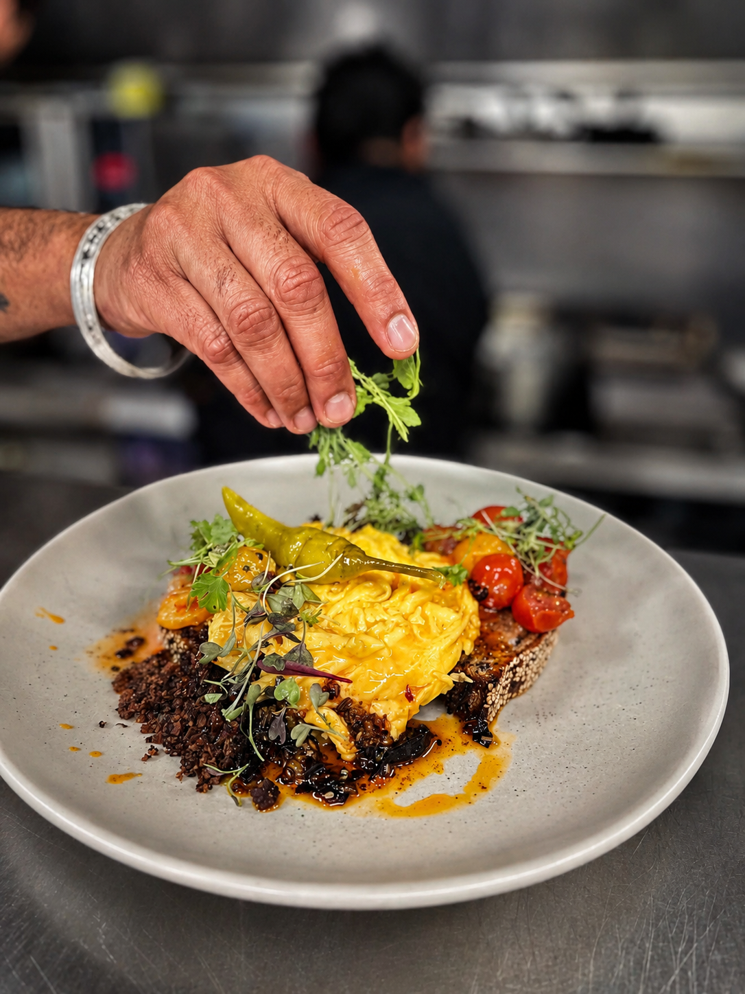 An egg-based brunch plate being finished at Heirloom Café